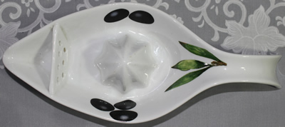 Top view of a white with olives 'gravy jug' like ceramic juicer 