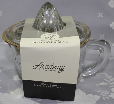 A packaged Academy 2 piece clear glass juicer