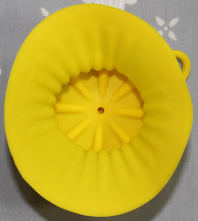 The bottom view of a yellow silicone lemon sleeve juicer