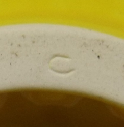 Insised mark on the base of a yellow ceramic saucer short pip collector juicer 