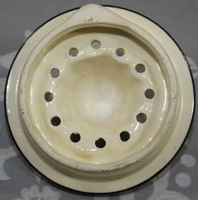 Bottom view of a cream with black trim ceramic reamer