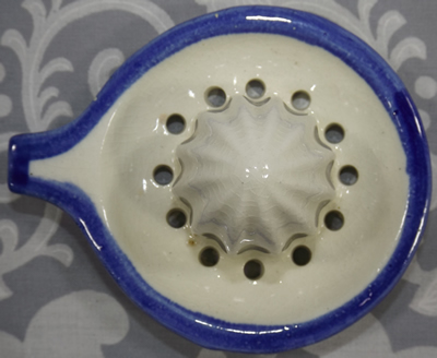 Top view of a blue and white ceramic reamer with grip