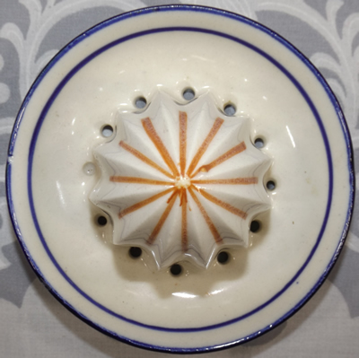 Top view of a white with blue and brown trim ceramic reamer