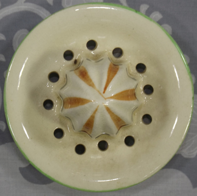 Top view of a cream with green and brown trim ceramic reamer