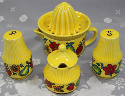 A fruit and flowers on yellow Goebel juicer with condiment set