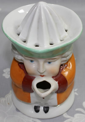 The front of a orange with pale green hat red collar1 piece toby juicer