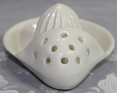 Front view of a white Goebel ceramic strainer juicer