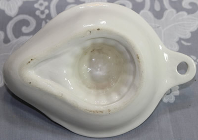 The open base of a white Goebel ceramic strainer juicer