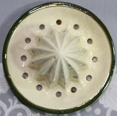 Reamer for a beige pot like with green leaves ceramic juicer