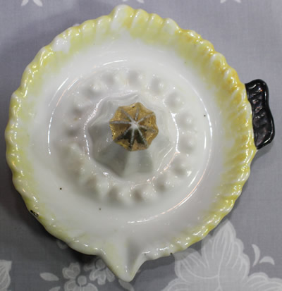 Top view of a yellow & black on white ceramic juicer