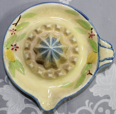 Top view of a blue on cream with lemons and leaves ceramic saucer juicer