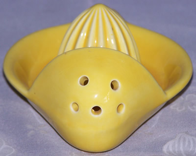 The strainer holes on a yellow Goebel pocket strainer juicer