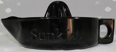 Side view of a black glass Sunkist juicer.