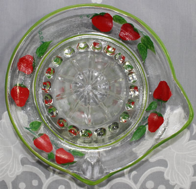 Top view of the painted strawberries on clear glass saucer juicer