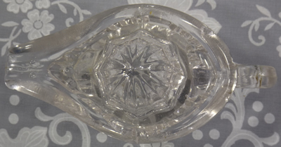 Small clear glass Aladdin lamp juicer with diamond pattern top view