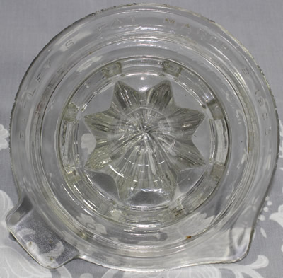 The embossing on an EASLY'S IMPROVED PAT. MARCH 6 1900 clear glass saucer juicer