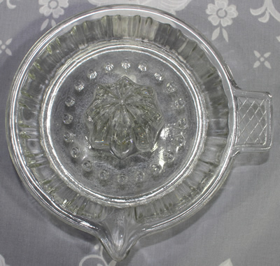 Top view of lattice pattern tab handle clear glass saucer juicer