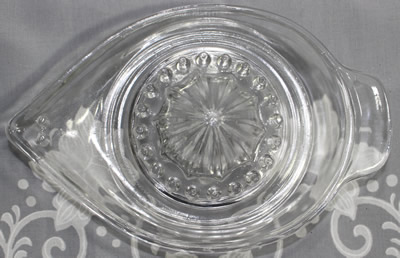 Top view of an embossed lemons on a clear glass jug like juicer