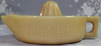 Side view of a McKee Glass Company dark caramel SUNKIST juicer