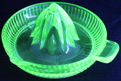 An Anchor Hocking Glass Co. green glass fluted bowl juicer under UV light