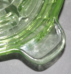 The tab handle on an Anchor Hocking Glass Company green glass juicer