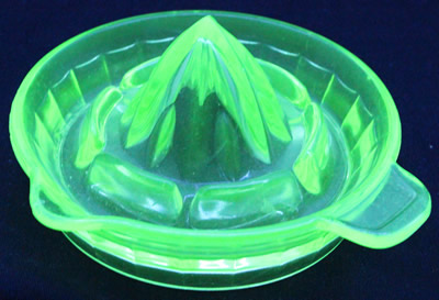 An Anchor Hocking Glass Company green glass tab handle juicer under UV light