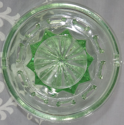 Bottom view of a notched pale green L E Smith juicer insert