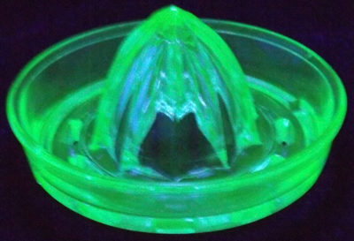 A notched pale green L E Smith juicer insert under UV light