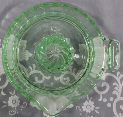 Top view of a clockwise spiral 1 piece pale green glass juicer
