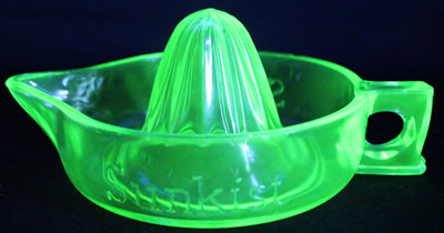 The green uranium glass curved handle Sunkist juicer under UV light