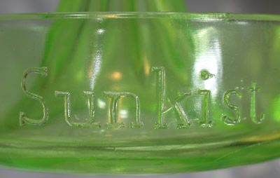 Embossing on a the face of a straight handle green Sunkist juicer