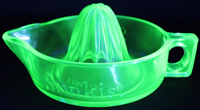 A straight handle green Sunkist juicer under UV light