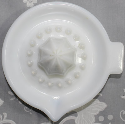 Top view of a white milk glass 29 panels saucer juicer