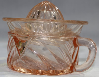 Side view of an arch pattern 2 piece pink glass juicer