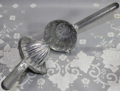 An open aluminium hinged hand held squeezer juicer