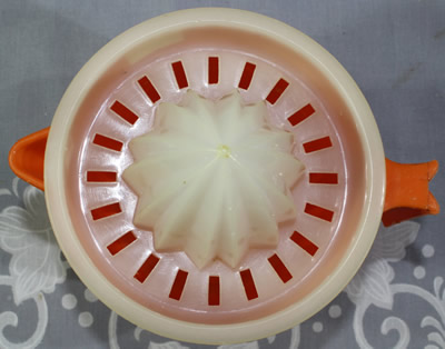 Top view of an orange jug and white plastic juicer