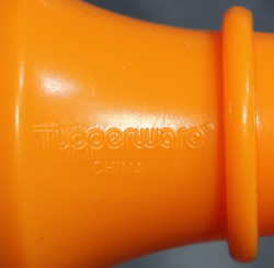 Embossed trademark on a Tupperware orange screw in insert juicer