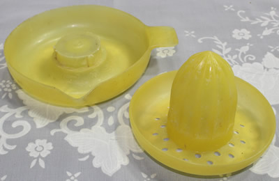 The 2 parts of a Duperite Everware translucent yellow plastic juicer