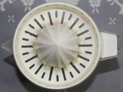 Top view of a clear plastic Hostess juicer with white locking top