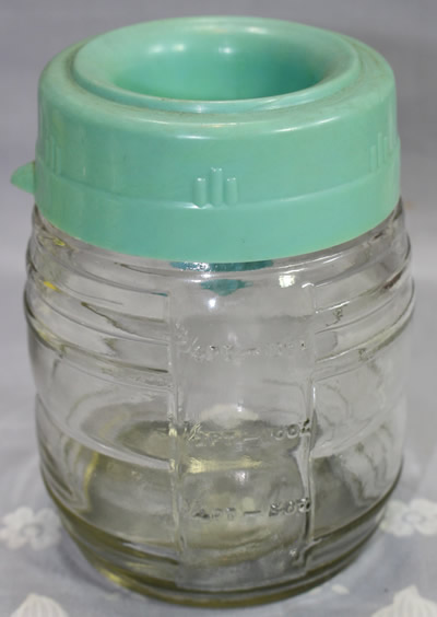 Closed Pastel green plastic juicer on glass jar