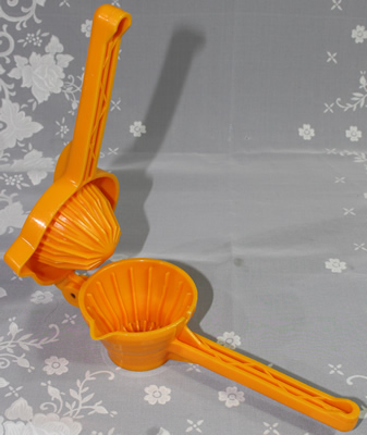 An open Lillo orange plastic hand held lever juicer