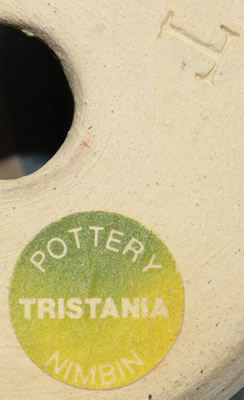 The label and potter's mark on a beige, blue and green/grey coloured pottery bowl juicer