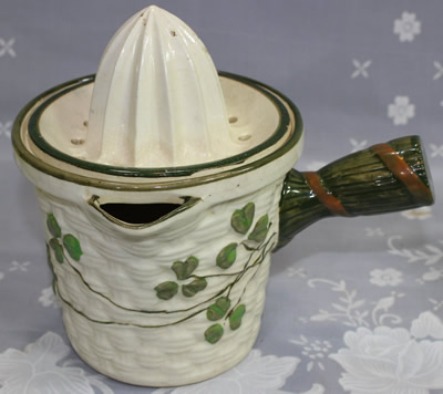 A beige pot like with green leaves ceramic juicer