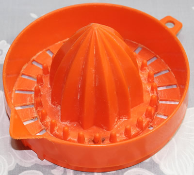 An orange plastic juicer top with pip collectors