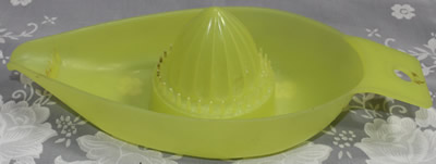 A translucent yellow Marquis plastic boat shape juicer