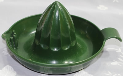 A dark green saucer shape juicer with a looped tab handle