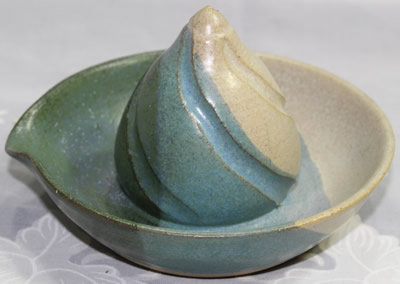 Beige, blue and green/grey coloured pottery bowl juicer